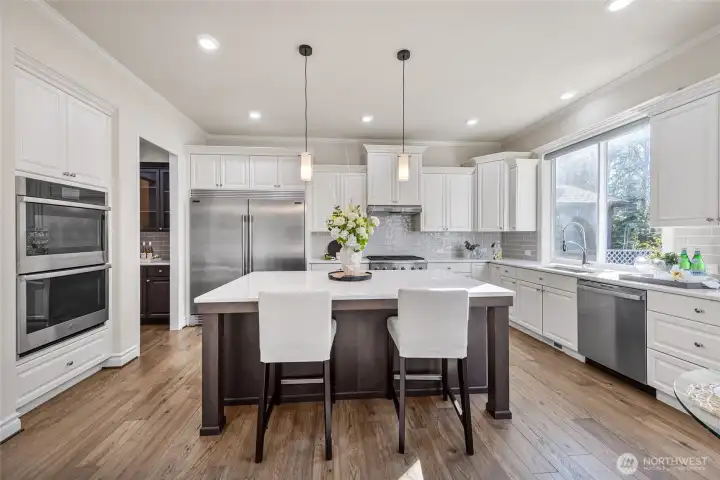 Kitchen with large center island, double oven and super-sized fridge.