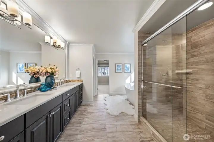 Luxurious primary bath with dual vanity, large walk-in shower, separate tub, and walk-in closet.