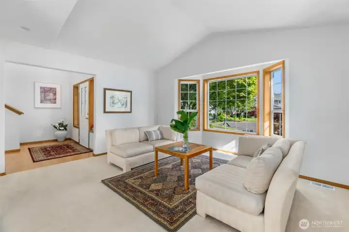 The lving room with views to the front of the home is open and airy, with vaulted ceiling. Open to the dining room and entry for great flow for entertaining. The lving room with views to the front of the home is open and airy, with vaulted ceiling. Open to the dining room and entry for great flow for entertaining.