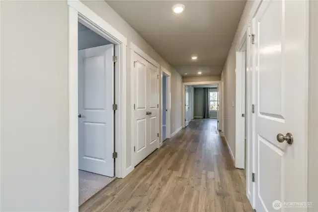 Grand hallway upstairs, with bonus room on one end and primary suite on the other. Ample storage here as well.