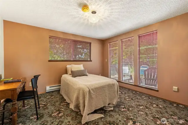 Large primary bedroom has multiple windows and tons of natural light.