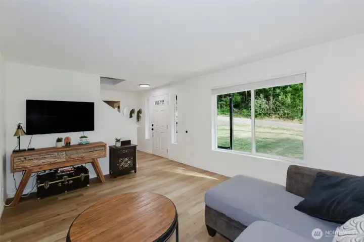 Bright, open living room with laminate flooring and large windows letting in natural light