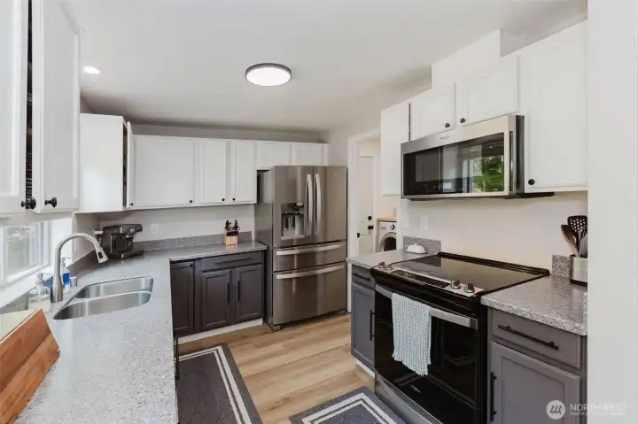 Updated kitchen with stainless steel appliances and laminate flooring.