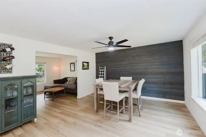 Bright dining space with feature wall and laminate flooring.
