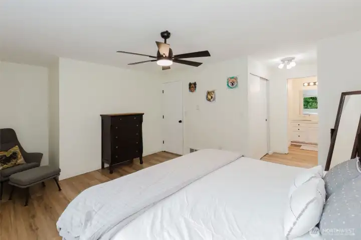 Primary bedroom retreat with ceiling fan and laminate flooring.