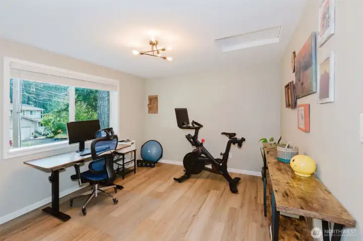 Bonus room staged as a home gym with laminate floors.