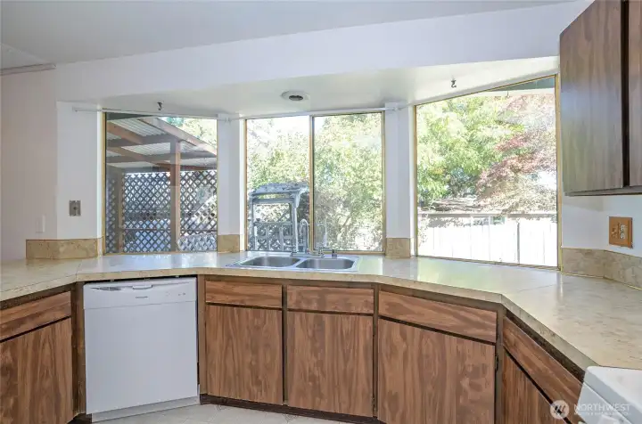 Kitchen windows overlooking the backyard bring in light and a connection to the outdoors.  Generous counter space perfect for cooking, baking, and entertaining.