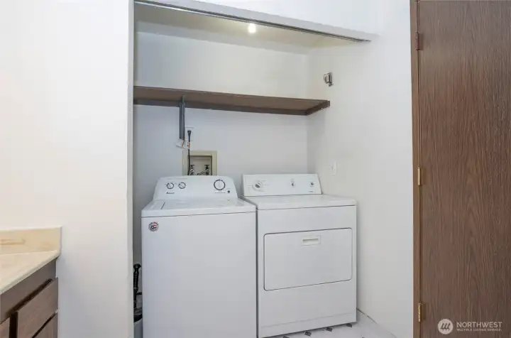 Laundry area with built-in shelving; washer and dryer not included.