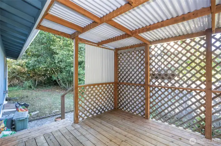 Covered deck with a step-down leading to one side of the yard.