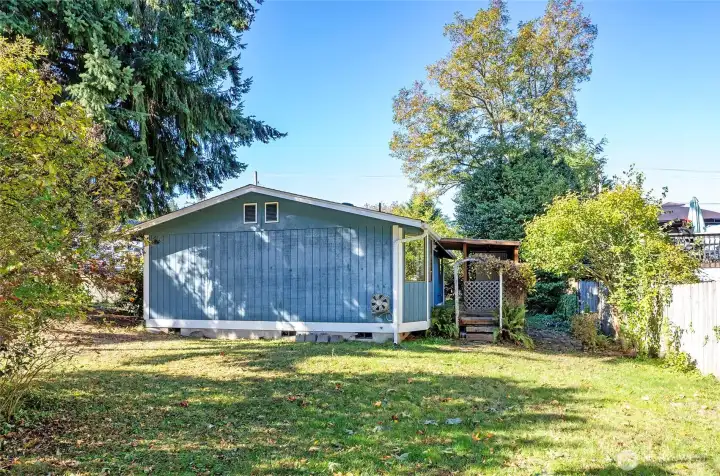 Additional deck access on the opposite side opens to a spacious, fully fenced yard.
