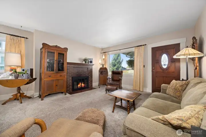 Once inside, you will see that the character of the home is still intact and there are (supposedly) fir or oak floors under this carpet. The wood burning fireplace has not been used in many years and is quit the focal point of this spacious living room.