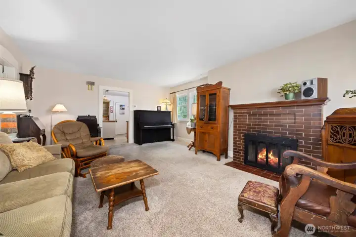 Looking toward the kitchen across the spacious living room. The lovely upright piano can remain with the sale of the home should someone wish.
