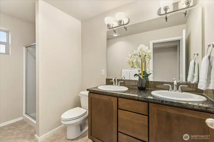 Primary Bath with shower, dual vanities, granite counters.