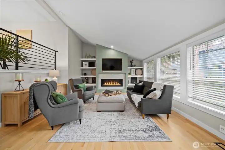 Living room has been extensively remodeled, to include, a custom fireplace with built-in shelving, refinished solid oak hardwood floors, and custom iron railing.