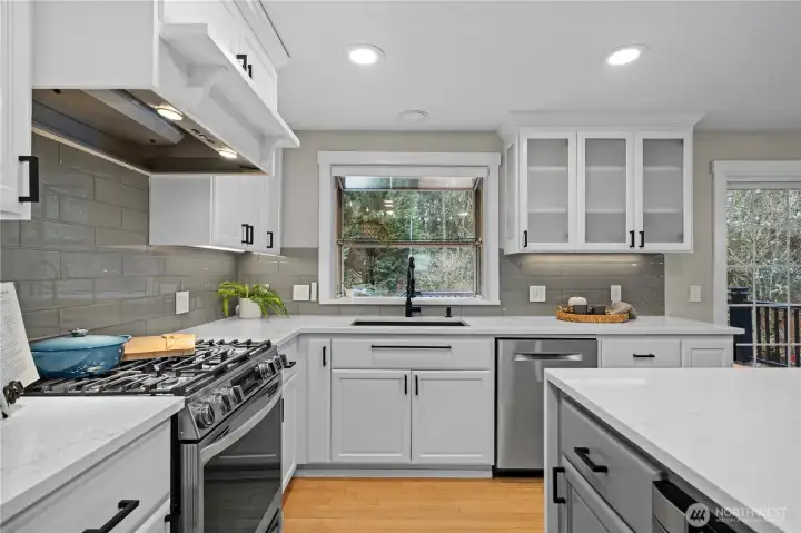 Updates include: glass tile baclsplash, updated sink and faucet, refrigerator, window trim and painted cabinets.