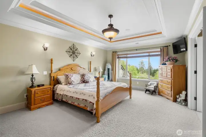 Primary Bedroom with River View and Tray Ceiliing Lighting