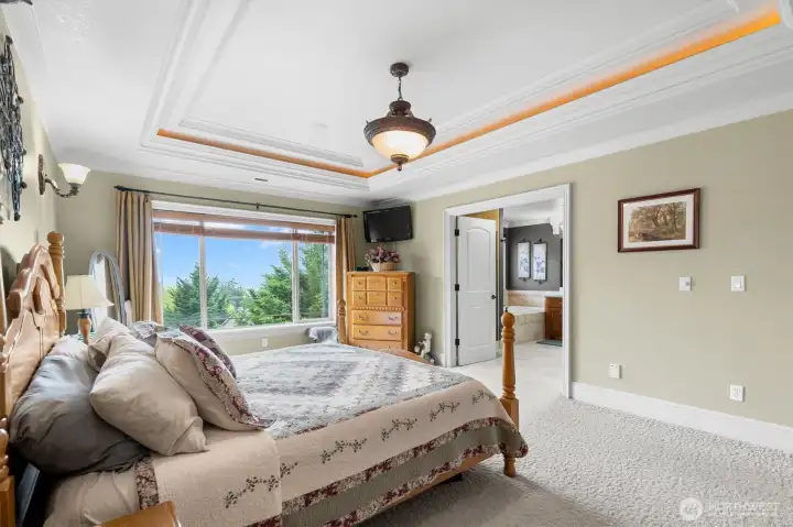 Primary Bedroom with River View and Tray Ceiling Lighting