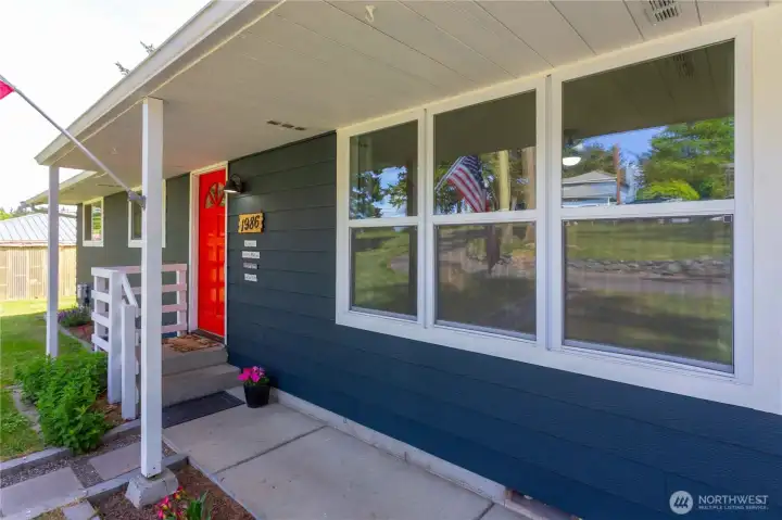 Cute & tidy front porch with concrete walkway