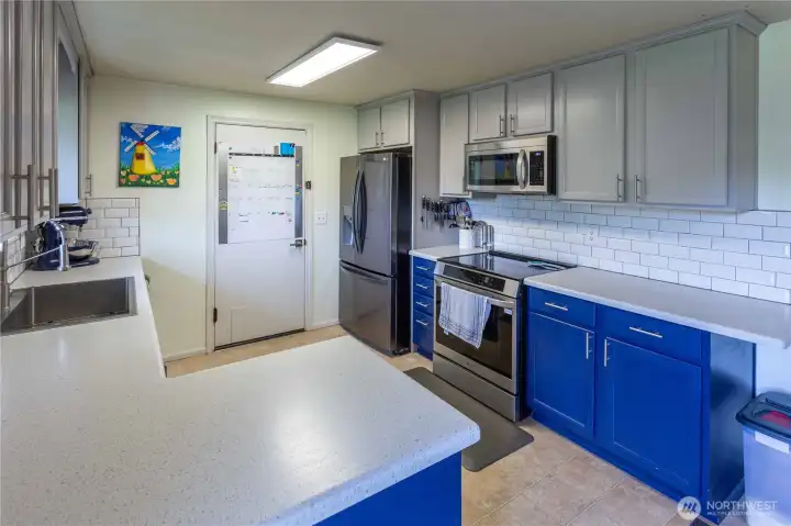 Kitchen looking toward door to attached garage w/ laundry area