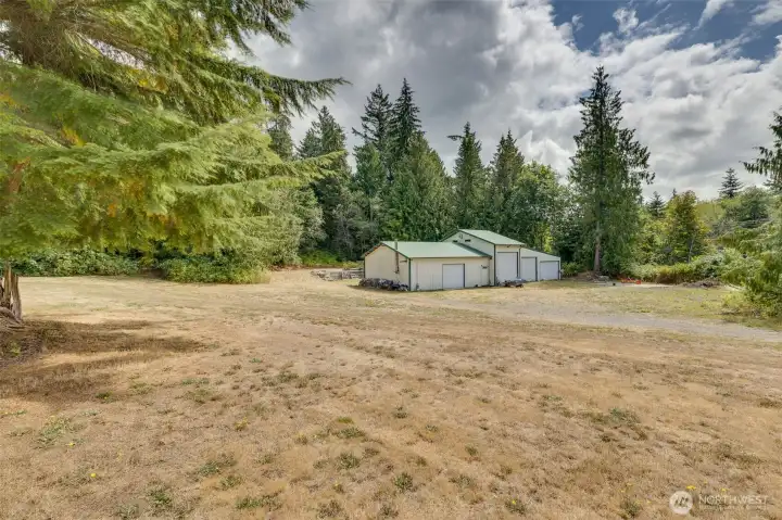 Large 4 bay shop garage with covered RV parking in the back with hook ups. This also has plans approved for a second drainfield for possible ADU.