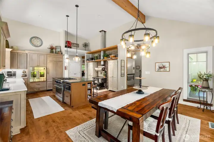 The soap stone island is highlighted by soaring ceilings, custom cabinetry, wall oven, cabinet refrigerator and dishwasher and the wonderful Blue Star 6 burner range!