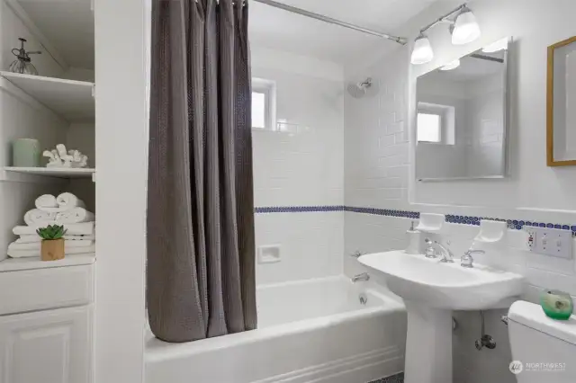 The newer full bath features a pedestal sink & stylish tile accents.