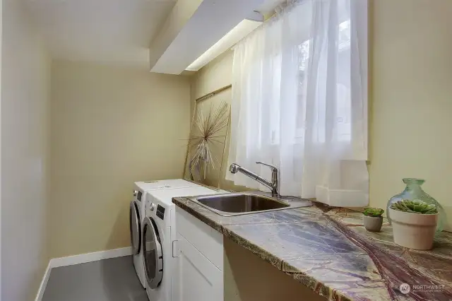 Full laundry room with utility sink and handy counter space.