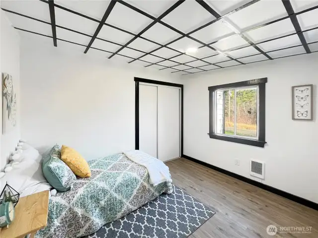 Spacious second bedroom featuring a coffered ceiling, natural light, and a convenient closet.
