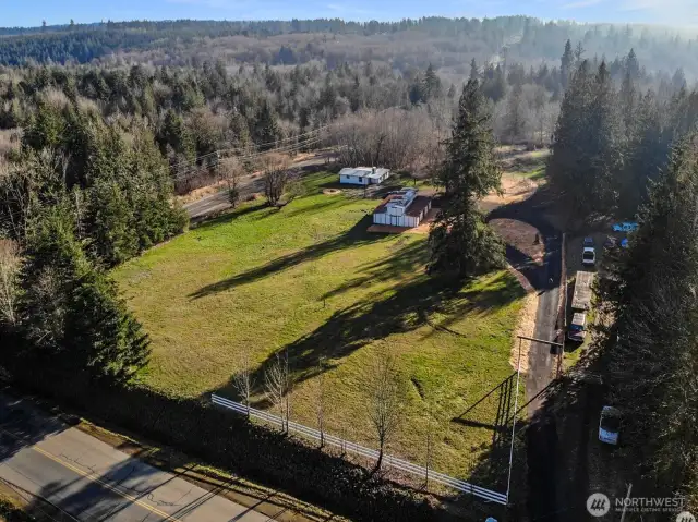 Drone shot captures the property's well-planned setup with home, barn, corral, and open acreage.