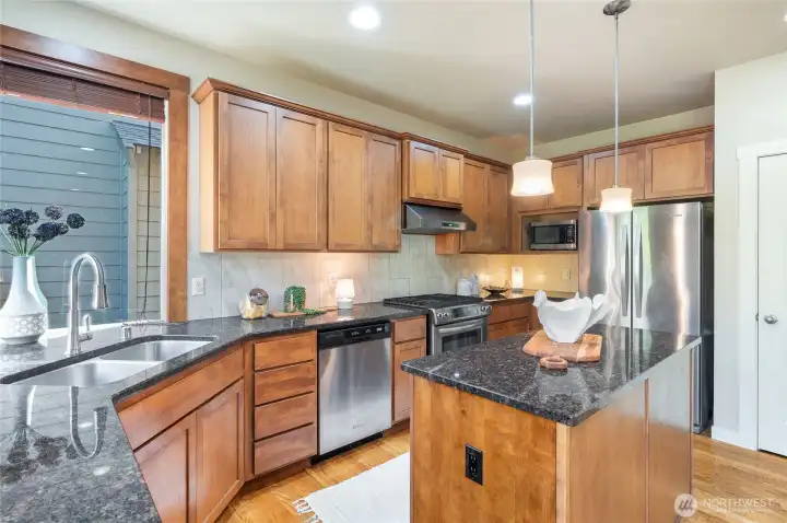 Striking granite countertops with plenty of prep space and full-height backsplash that adds style.