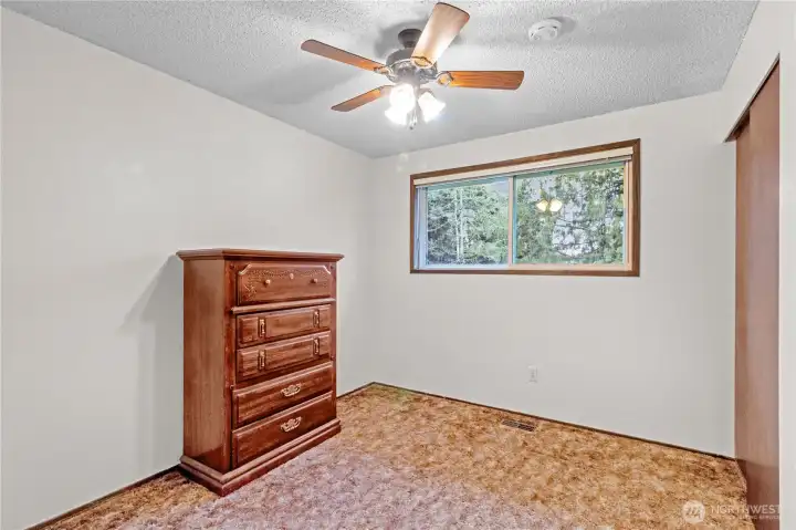 Additional upstairs bedroom w/ window overlooking the fully fenced backyard.