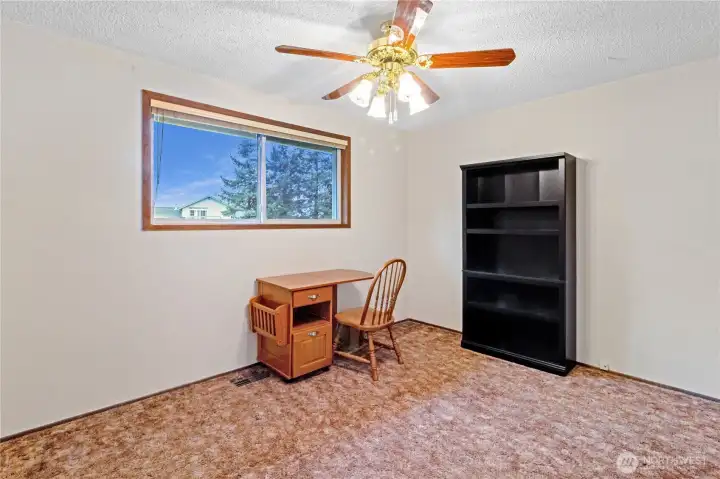 Third upstairs bedroom w/ large window & ceiling fan.