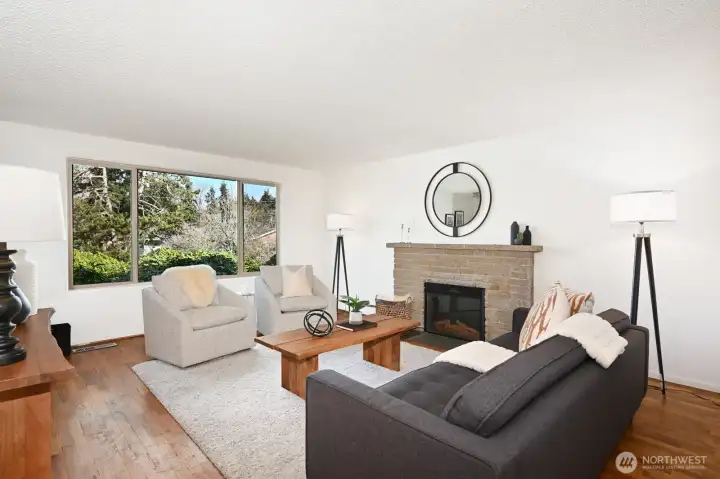 Light-filled living room, complete with the fireplace and hardwood flooring.