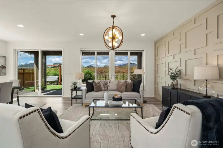 The spacious great room with the stunning feature wall, high-end lighting (throughout)and generous windows overlooking the beautiful and private outdoor space.