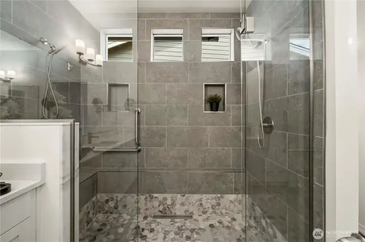 Designer inspired extra-large shower with dual shower heads, bench and niche.