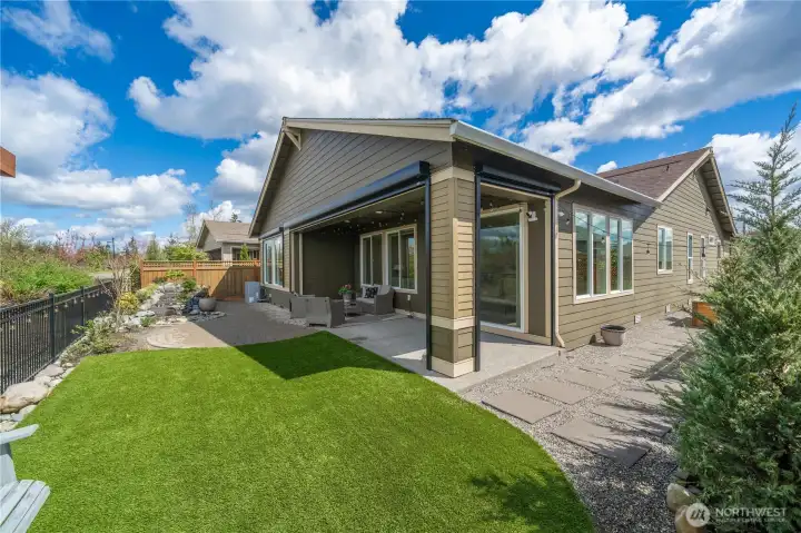The large, raised covered patio offers motorized sunshades and leads to a level yard with hardscape, high-grade turf and a stunning water feature which is illuminated at night.