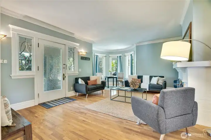 The front door from the covered porch opens to the living room with its rounded bay window nook - even the panes of glass are curved!