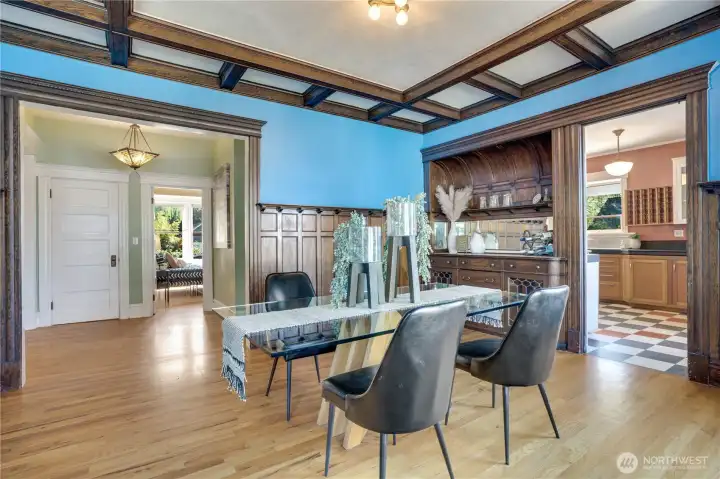 Board and batten paneling topped with plate rail trim lines the room with its easy access to the living room and into the kitchen.