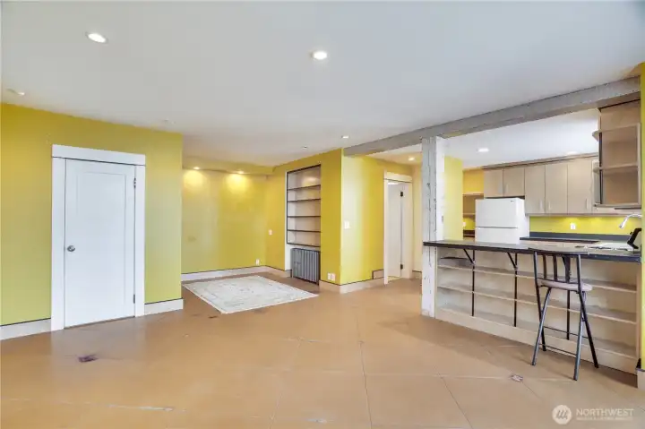 A side door opens from the graveled driveway into this 630 sq ft basement studio apartment which is currently vacant. The door on the left opens into a large closet.