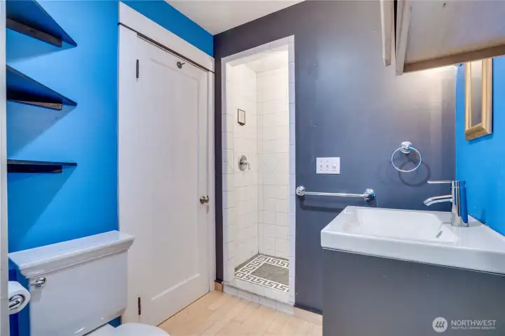 Reach the studio's 3/4 bath through a door in the kitchen. Notice the mosaic detail in the tiled shower floor.