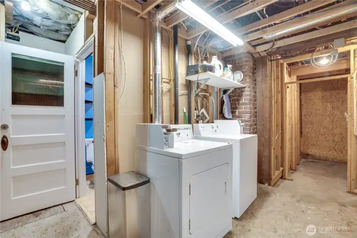 The basement includes 980 sq ft of unfinished space including this coin-op laundry area.
