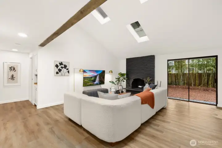 This room is oversized and allows for tons of seating - also perfect for entertaining! The bedrooms and bathrooms are down the hall to the left in this photo. Kitchen and dining are to the right.