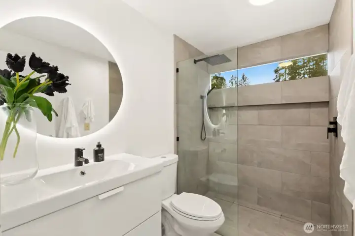 This remodeled primary bath has a walk-in shower and is one of two bathrooms in the home.