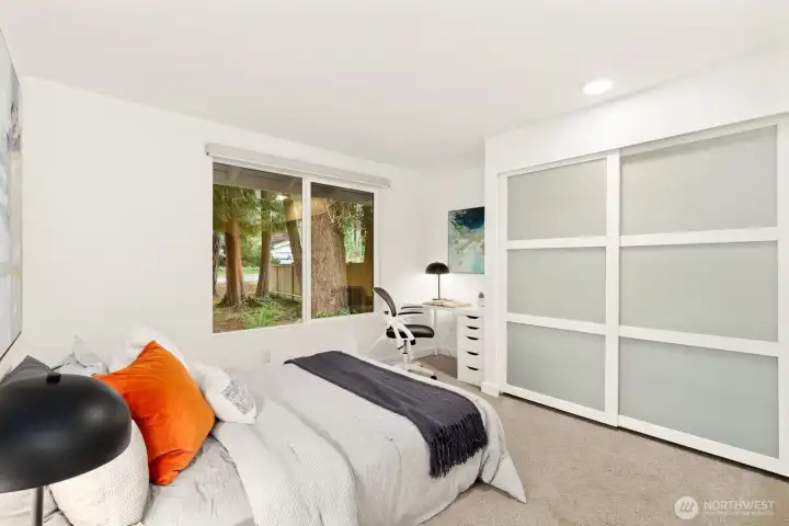 The second bedroom at the front of the house has a desk in the corner. Serene outlook to the trees!