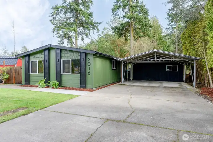 Extra large cement driveway with covered parking bay.