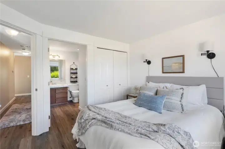 Another view of primary bedroom facing closet and en-suite bathroom.