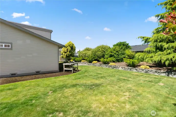 Expansive side yard - mature landscaping and built in sprinklers make this upkeep effortless.