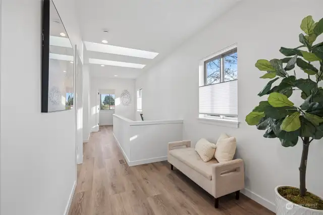 Upstairs foyer features LVP floors, office/sitting area, skylights and top down bottom up custom blinds.