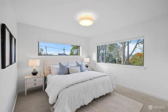 King sized primary bedroom with views of Port Gardener Bay. Spacious walk in closet with built in shelves and drawers. Custom window coverings and lighting.