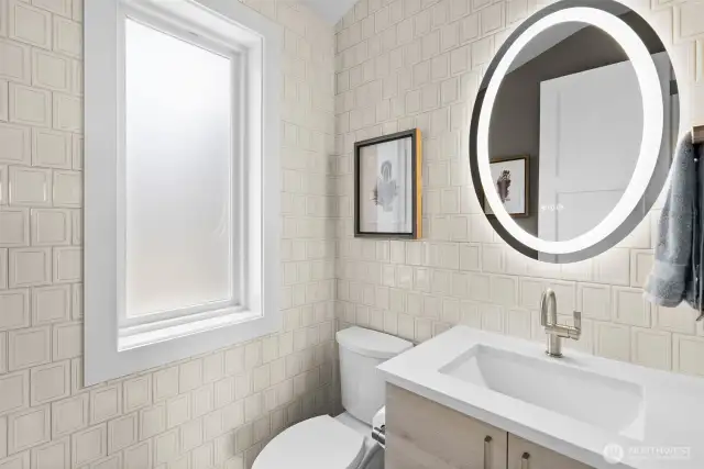 This stunning powder bath is beautifully adorned with elegant tile, creating a stylish and sophisticated space for guests.